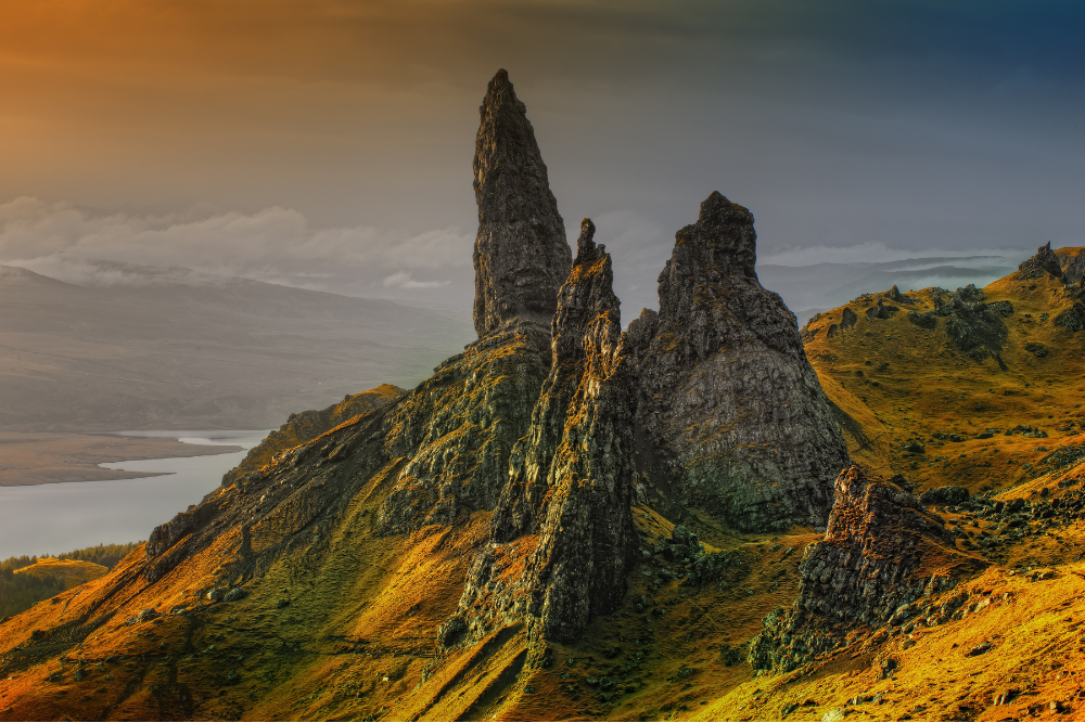 Scottish Highlands, jagged pinnacles, rolling hills and waterway, sunset glow, editorial travel photo, no people.