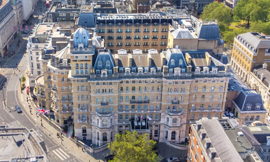 Aerial view of the Langham hotel building with dome roofs and surrounding city streets, London.