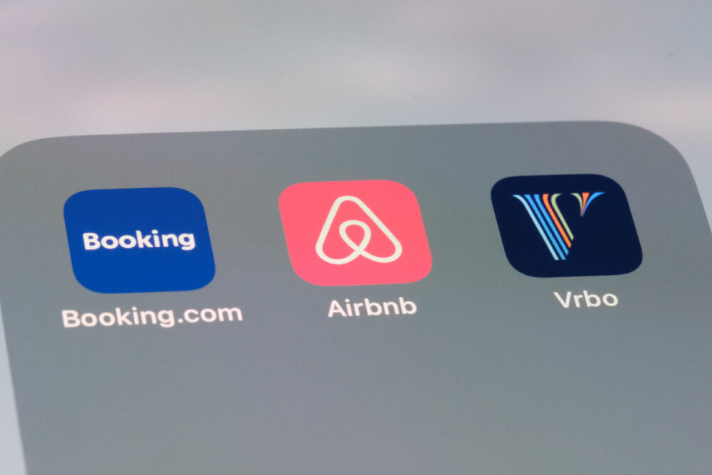 Icons for Booking.com, Airbnb, and Vrbo apps displayed on a smartphone screen.