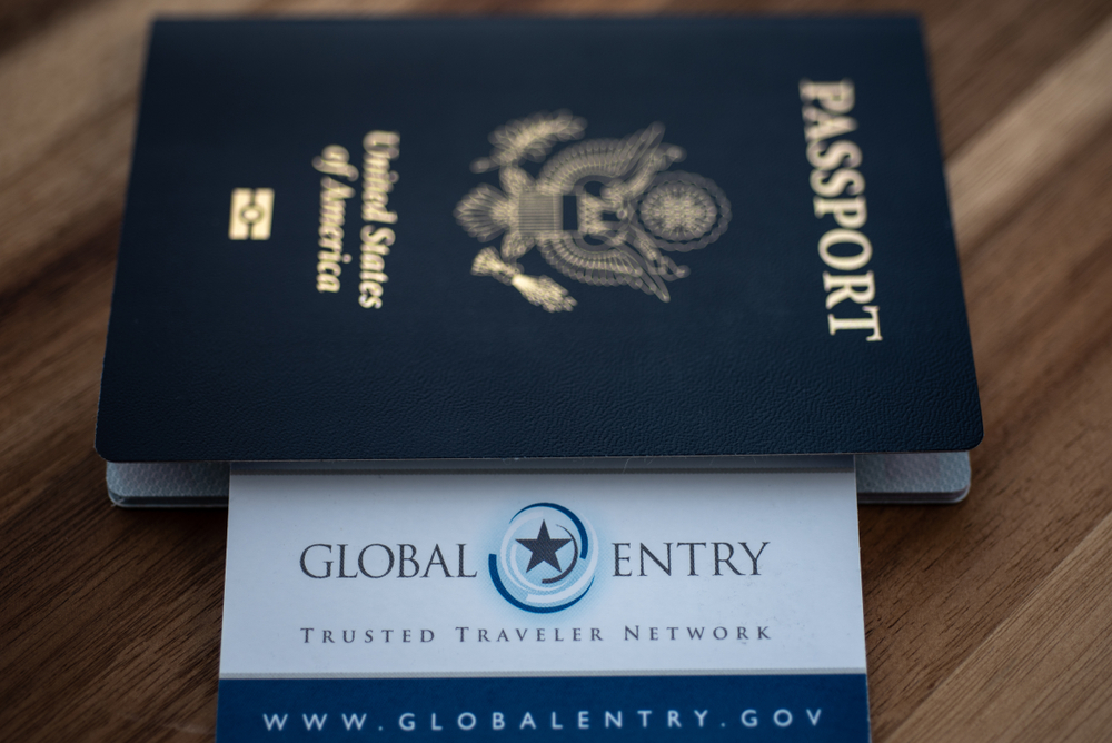 U.S. passport and Global Entry card on a wooden table.