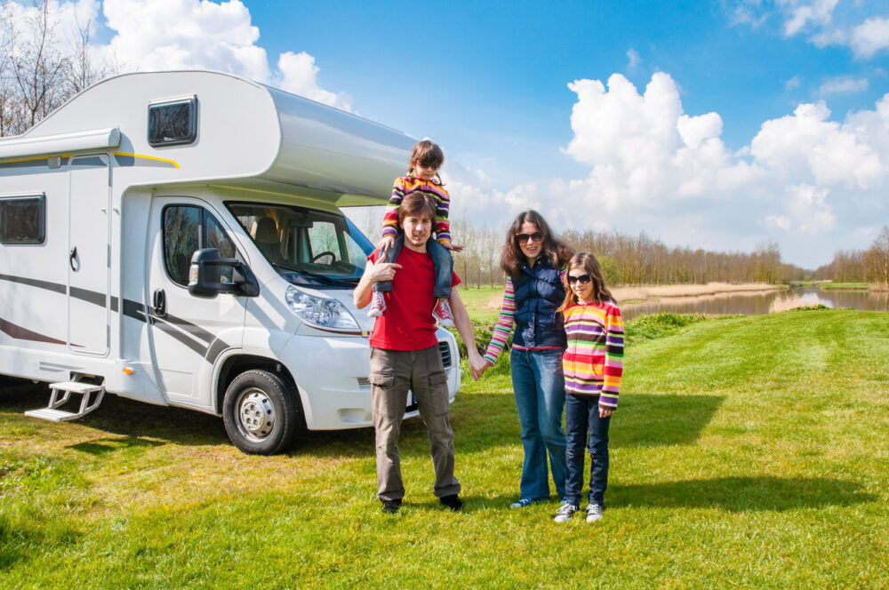 Family enjoying a sunny day outside an RV with kids in colorful clothing