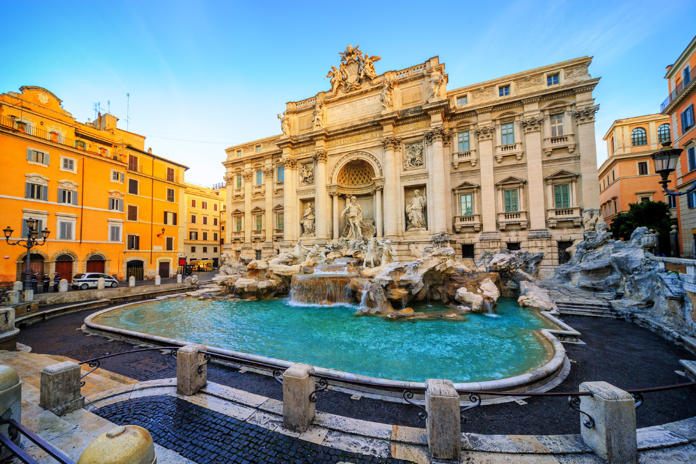 The Trevi Fountain in Rome with baroque architecture and flowing water, surrounded by historic buildings.