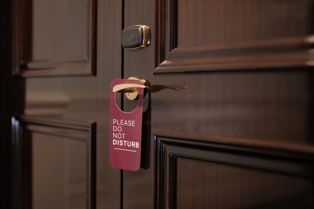 Brown door with a "Please Do Not Disturb" sign hanging on the handle.